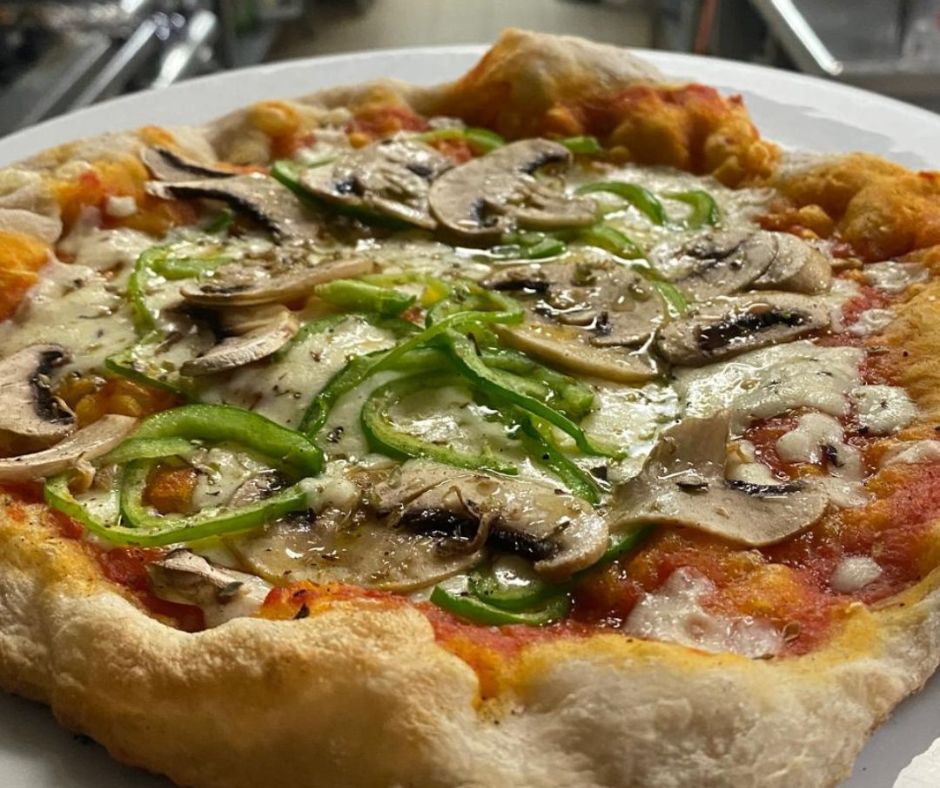 pizza artesana al forn de carbó amb massa natural i ingredients frescos preparada per emportar a restaurant la crosa sant dalmai girona